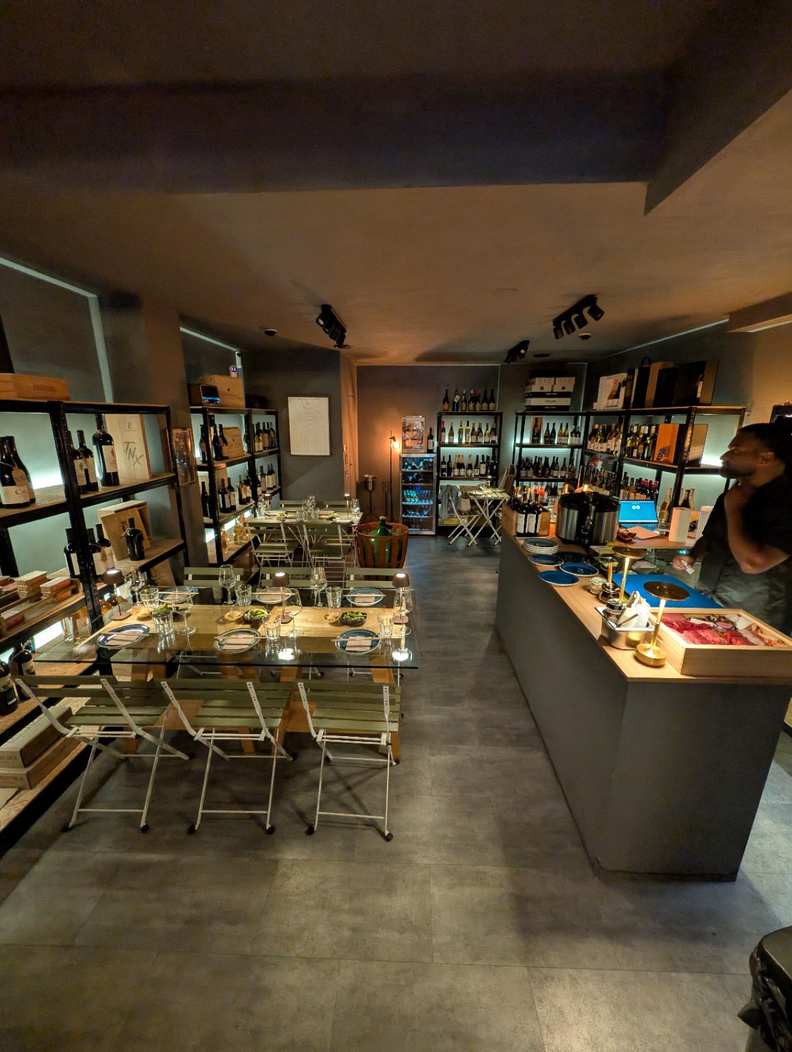 Mesas preparadas para um encontro de sushi na Winenonymous, com o balcão de preparação à direita